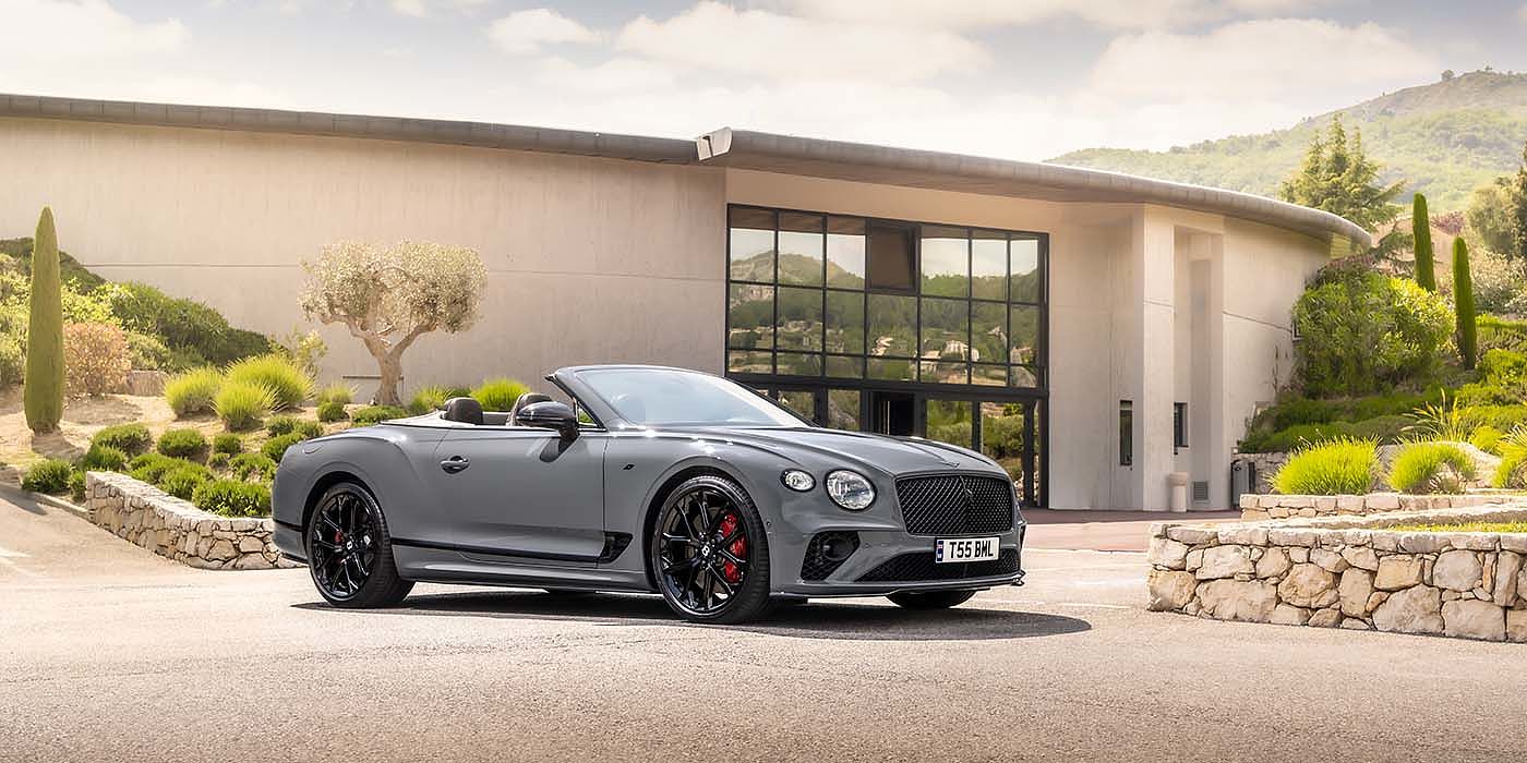 Emil Frey Exclusive Cars GmbH | Bentley München Bentley Continental GTC S convertible in Cambrian Grey paint front 34 static near house