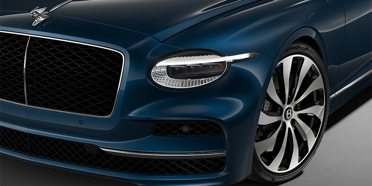 Emil Frey Exclusive Cars GmbH | Bentley München New Bentley Flying Spur sedan head lamp against Marlin blue paint with 22" Ten Spoke Black Painted and Bright Machined wheel