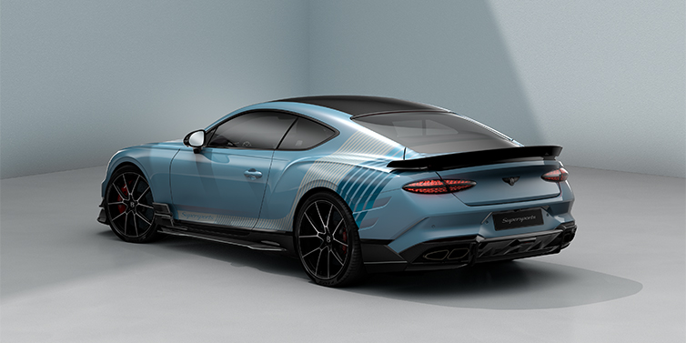 Emil Frey Exclusive Cars GmbH | Bentley München Bentley Supersports rear three quarter in "Daybreak" Design theme with Jetstream blue paint and Arctica white and Portofino blue paint stripes across the rear haunch.